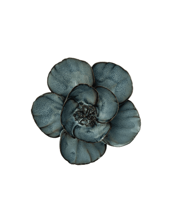 A single flower-shaped decorative object with five rounded petals in a mottled slate blue-gray color, isolated on a solid black background.