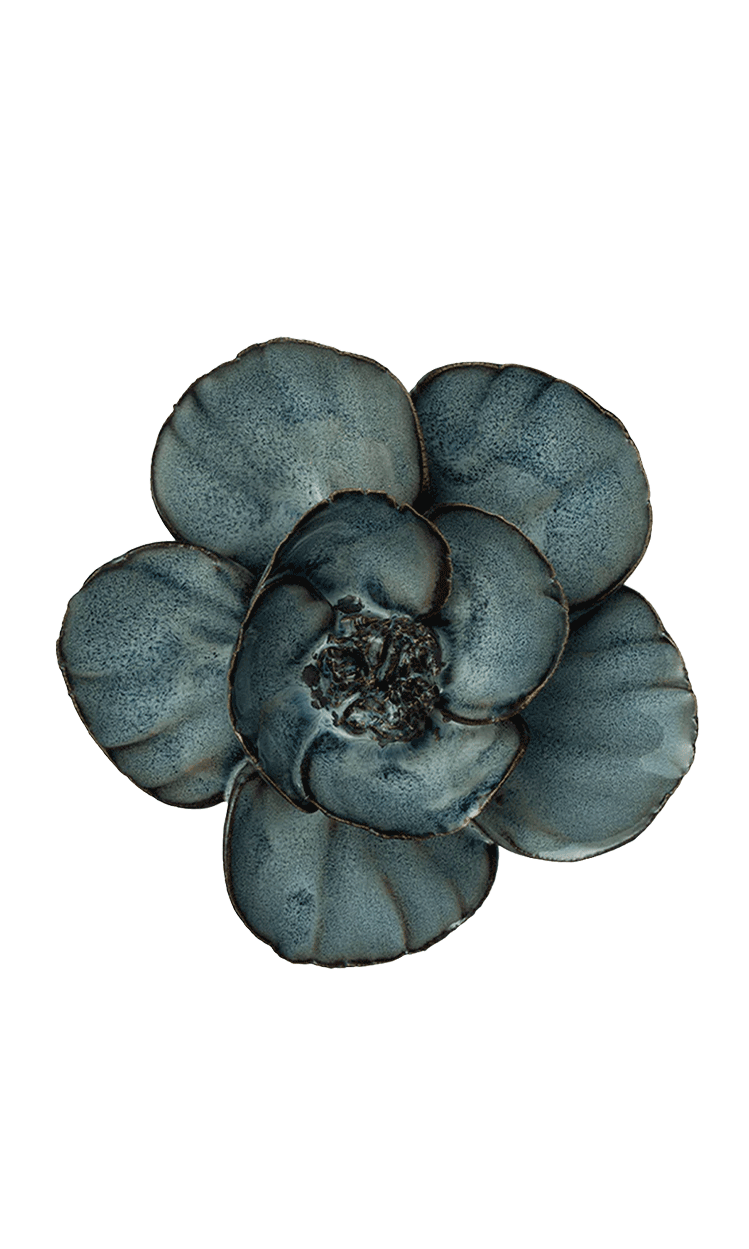 A single flower-shaped decorative object with five rounded petals in a mottled slate blue-gray color, isolated on a solid black background.