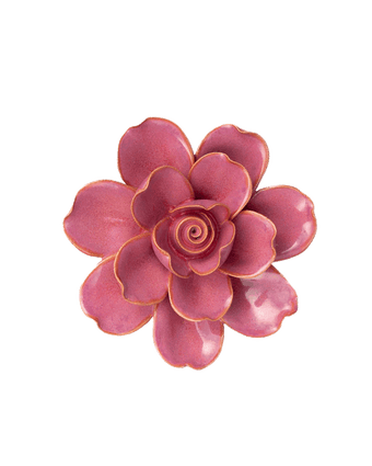 A single artificial-looking flower with layered petals in a dusty rose pink color, outlined with a thin metallic gold edge, isolated on a solid black background.