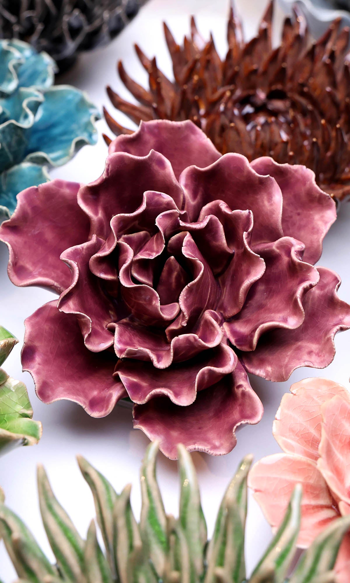 Lettuce Purple ceramic wall flower styled on a white table with other flowers — Chive Studio