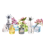 Chive Loft glass bud vase collection mixes clear, amber, sage, and blue jars in round and square shapes.