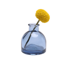 Chive Loft round glass bud vase in medium blue styled with a single yellow billy ball bloom.