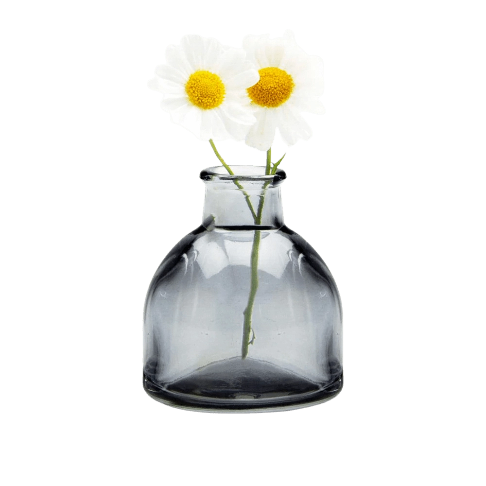 Chive Loft round glass bud vase in smoke grey styled with two small white daisy blooms.