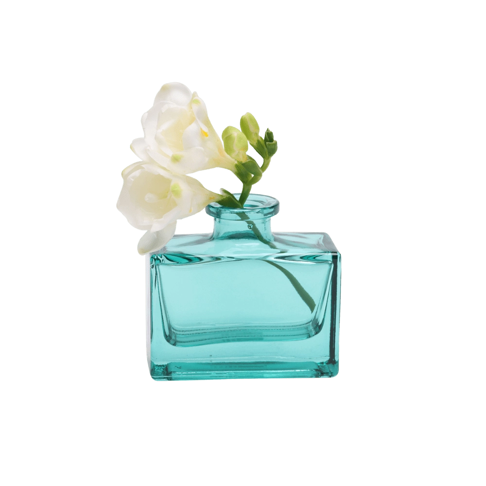Chive Loft glass bud vase in Teal holds white freesia blooms with trailing green buds.