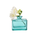 Chive Loft glass bud vase in Teal holds white freesia blooms with trailing green buds.
