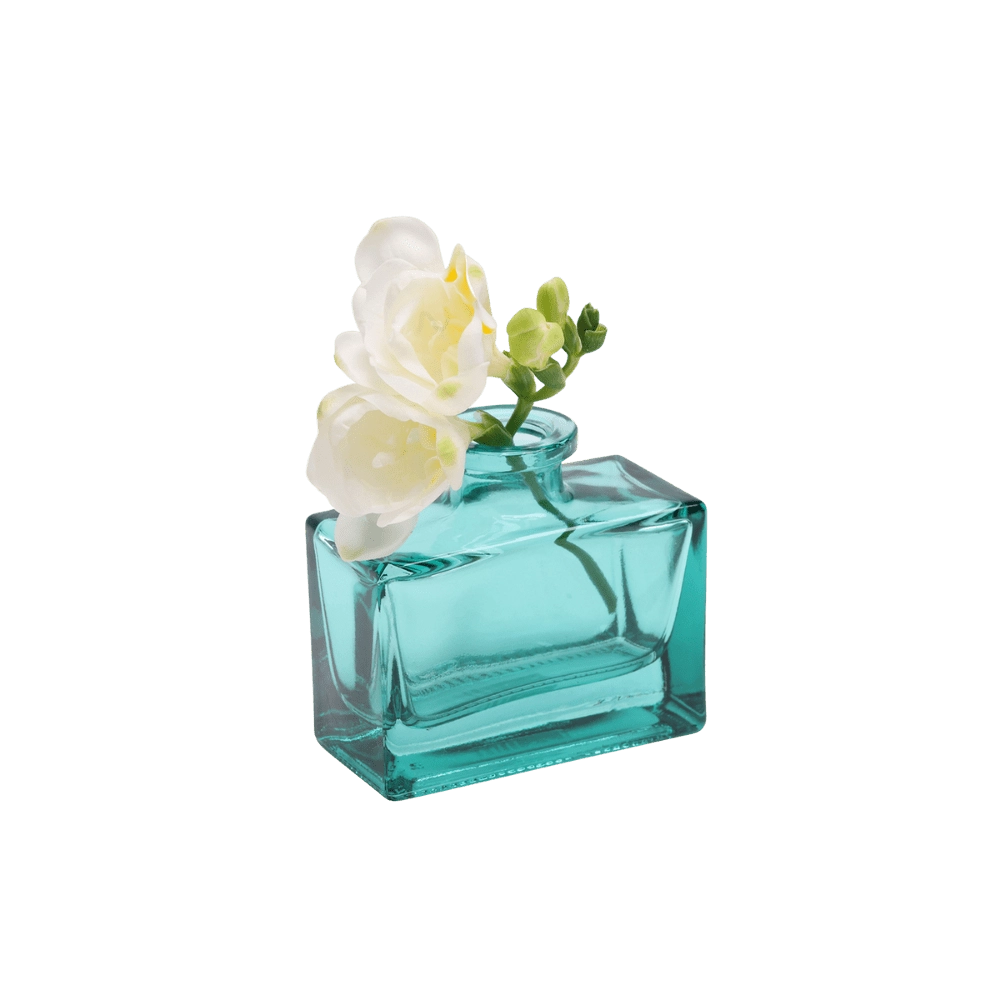 Chive Loft glass bud vase in Teal cradles white freesia at an angle, showing the jar's full shape.