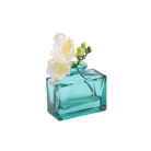 Chive Loft glass bud vase in Teal cradles white freesia at an angle, showing the jar's full shape.