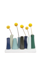 Chive Pooley ceramic bud vase set in Forest showcases cool-toned tubes in a tightly clustered mixed arrangement.