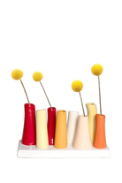Chive Pooley ceramic bud vase set in Strawberry Shortcake holds tall tapered tubes in warm mixed hues on a connected tray.