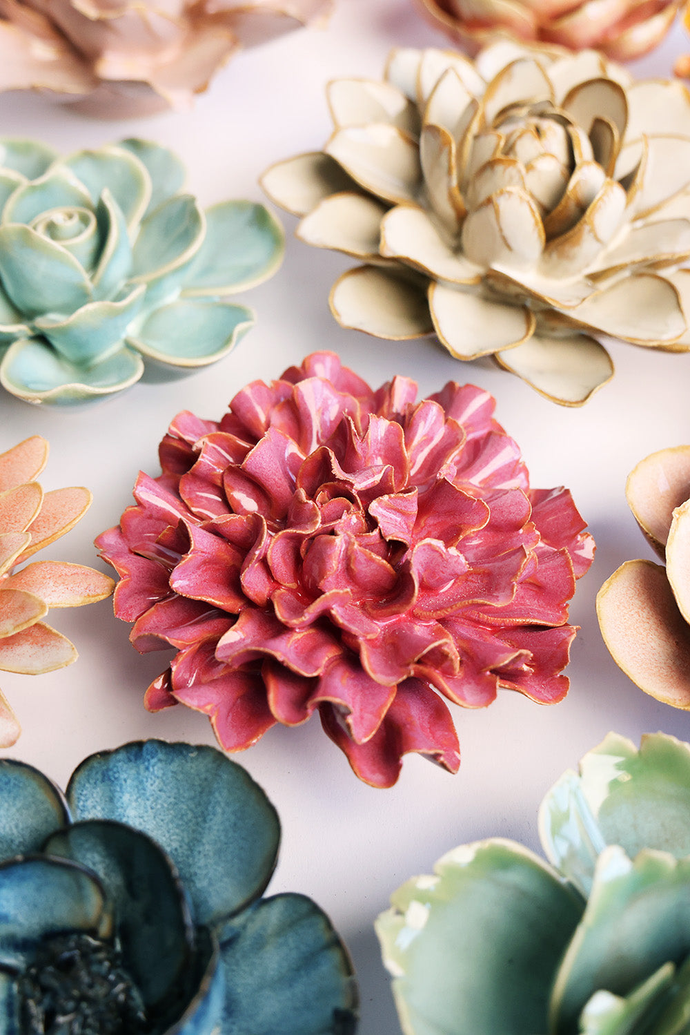 Blush Pink Tundra Carnation ceramic wall flower mounted on a wall — Chive Ceramics Studio