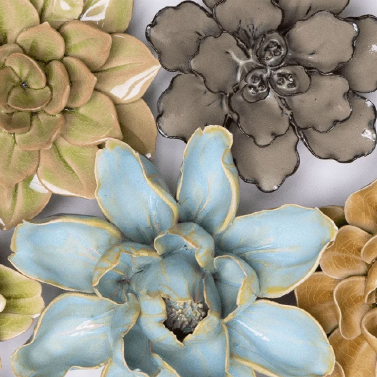 Three Chive ceramic flowers displayed together, featuring blue, brown, and green flowers.