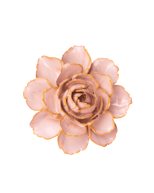 A single artificial flower bloom with pale blush pink petals and metallic gold edging, photographed from above on a plain white background.