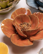 Close-up of the Chive August Birth Flower Poppy burnt orange ceramic flower among assorted Chive ceramic flowers.