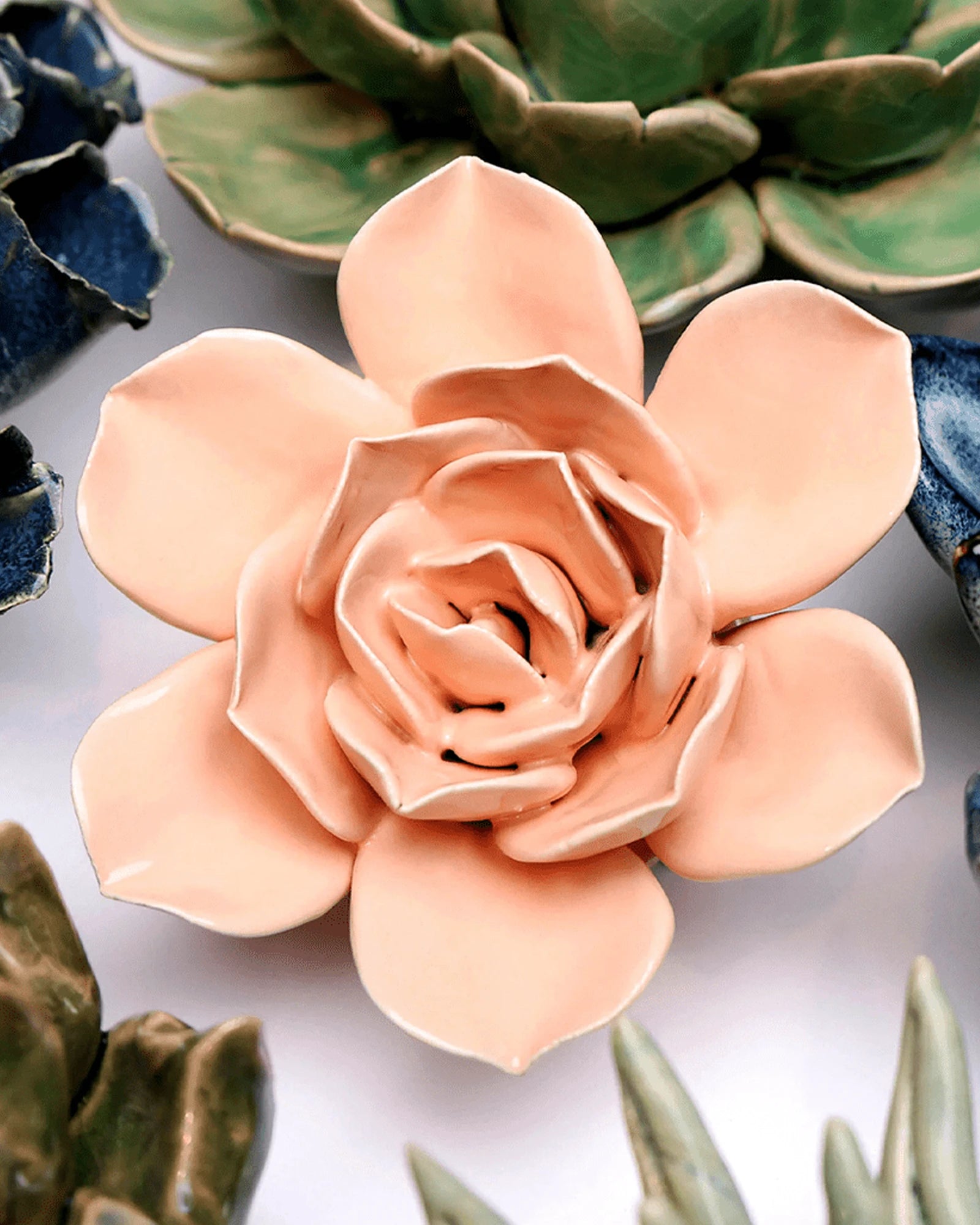 Close-up of the Chive December Birth Flower Narcissus apricot pink ceramic flower among assorted Chive ceramic flowers.