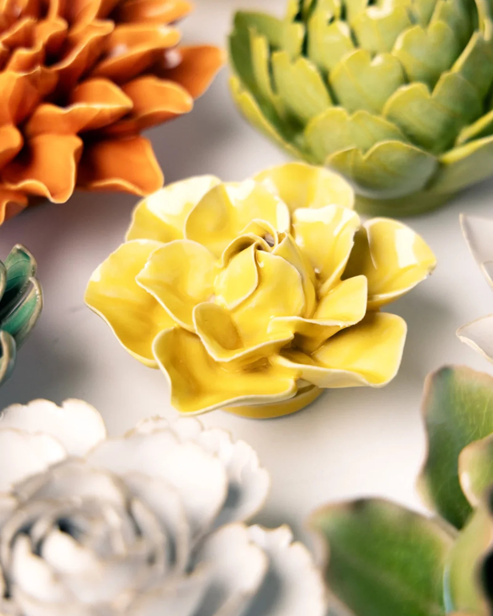 Close-up of the Chive March Birth Flower Daffodil yellow ceramic flower among assorted Chive ceramic flowers.