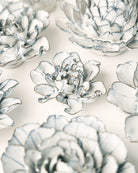 Close-up of the Chive May Birth Flower Hawthorn blue white ceramic flower among assorted Chive ceramic flowers.