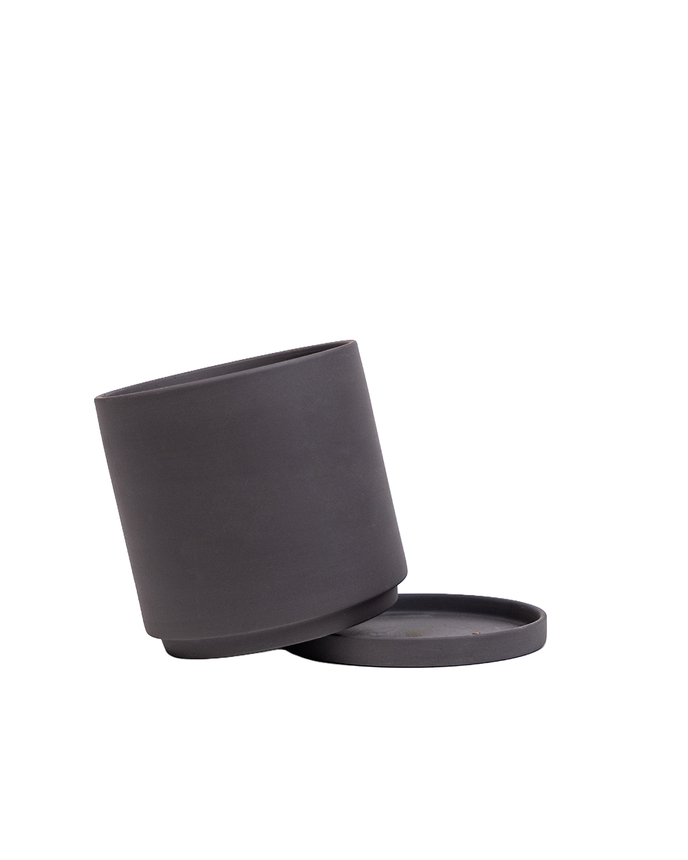 A matte black cylindrical container with its matching round lid resting beside it on a clean white background.