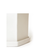 Close-up of the flat panelled surface and hexagonal saucer on a Chive Hexi white ceramic pot.