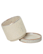 Chive Minute small ivory speckles ceramic pot with drainage tilted to show the detachable saucer.