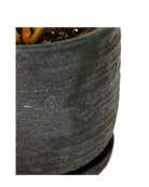 Close-up of the matte ribbed surface on a Chive Paul black ceramic small pot with saucer.