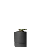 Close up of Chive Ryan black ceramic self-watering plant pot with drainage hole and detachable saucer.