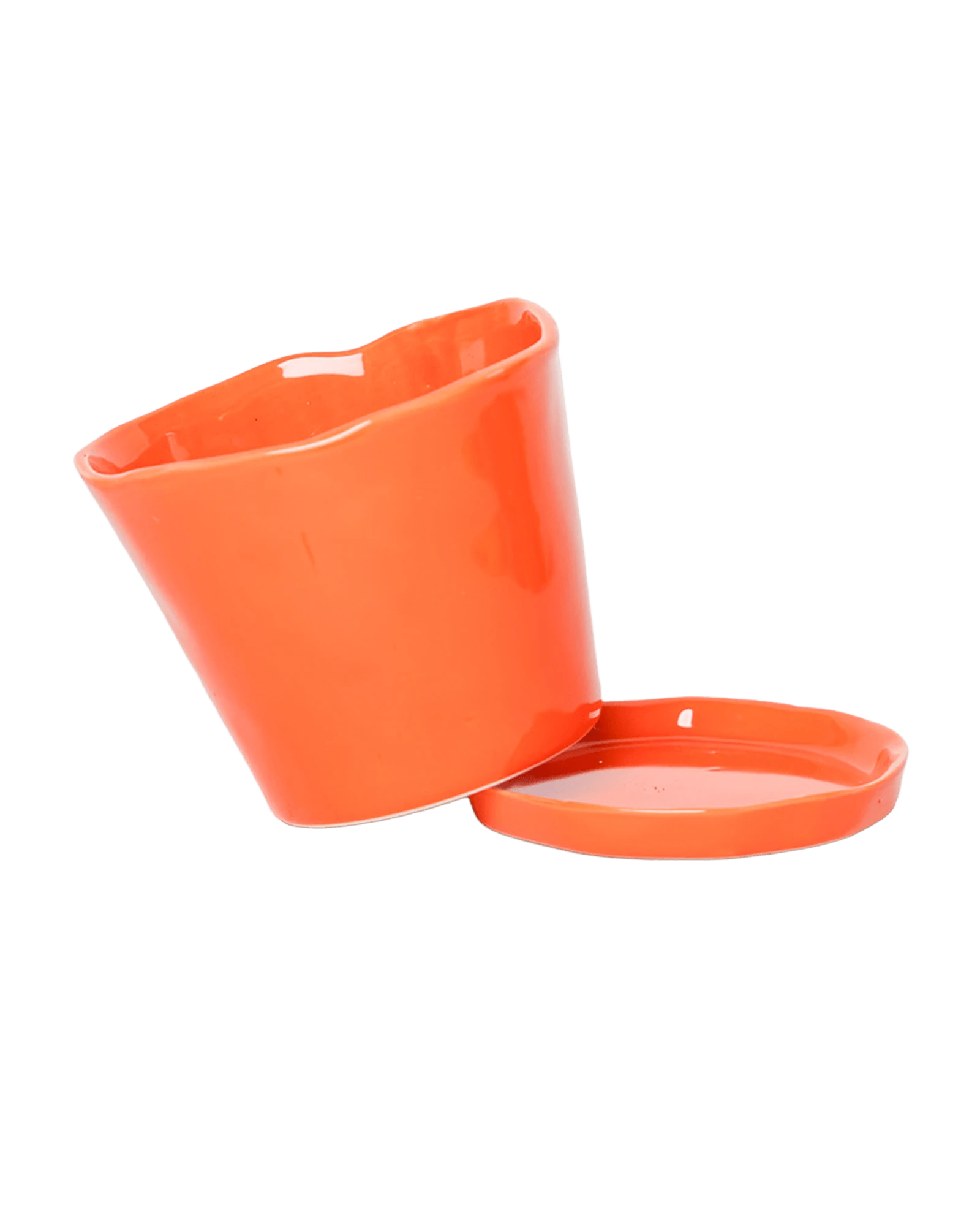 Chive Tika orange ceramic large plant pot with drainage tilted to show the detachable saucer.