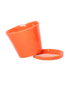 Close up of Chive Tika orange ceramic small plant pot with drainage tilted to show the detachable saucer, 