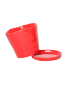 Close up of Chive Tika red ceramic small plant pot with drainage tilted to show the detachable saucer.