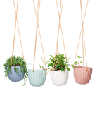 Chive Virago G ceramic hanging planters in blue grey, clay terracotta, peacock green, and white styled with plants.