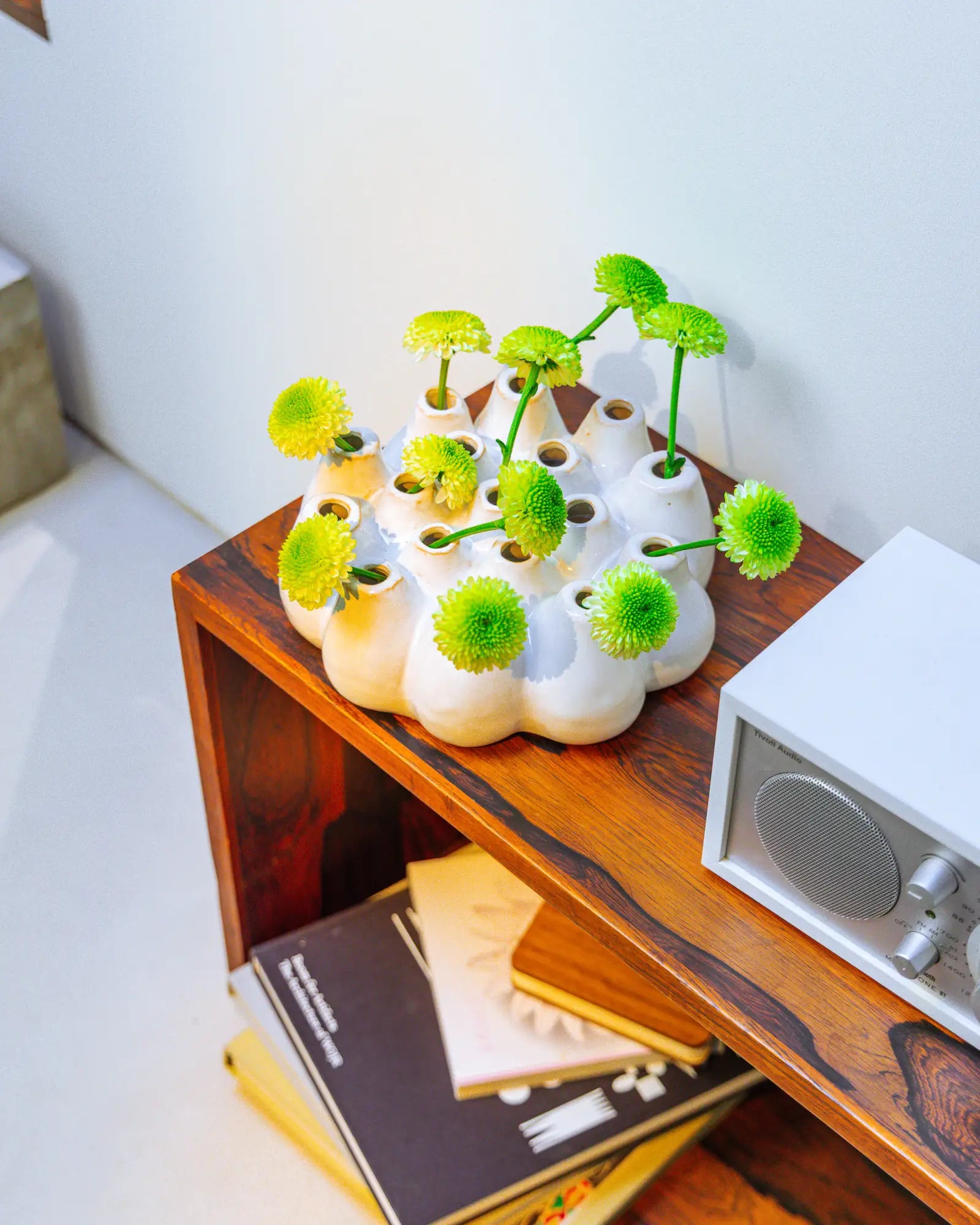 Chive Multi-Stem Pooley 3 Large Ceramic Vase syled with fresh flowers on a wood bookshelf.