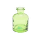 Chive Loft apothecary glass bud vase in green with a tall cylindrical silhouette and wide lip.