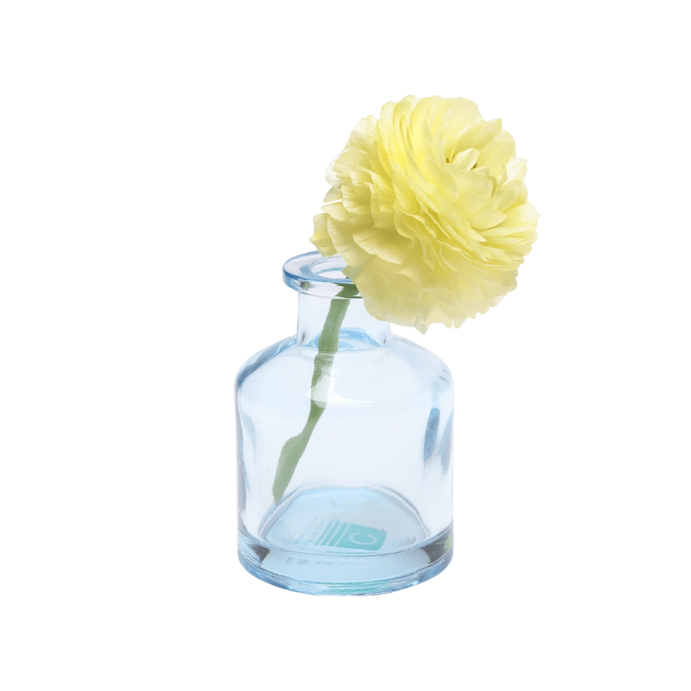 Chive Loft apothecary glass bud vase in light blue styled with a pale yellow ranunculus bloom.