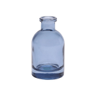 Chive Loft glass bud vase in medium blue with a narrow neck and rounded cylindrical body.