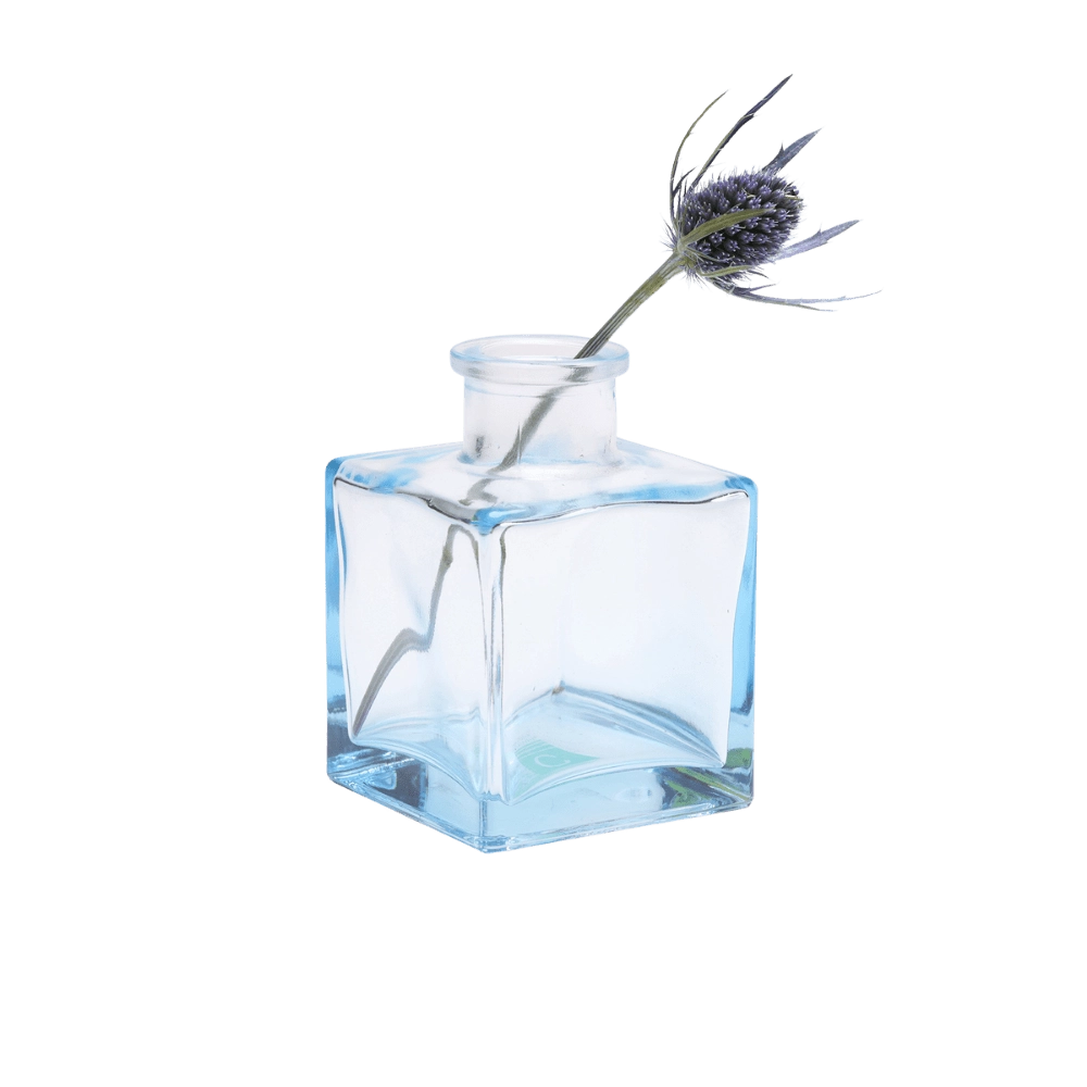 Chive Loft cube glass bud vase in light blue styled with a single blue thistle stem.