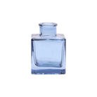 Chive Loft cube glass bud vase in medium blue, shown at an angle with a glossy faceted finish.