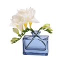 Chive Loft square glass bud vase in blue-grey holding freesia blooms, shown from a side angle.