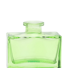 Chive Loft square glass bud vase in green, close-up on the narrow neck and thick glass base.