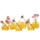 Chive Loft square glass bud vases in yellow grouped together, styled with mixed pink florals.