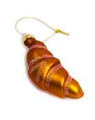 Chive glass croissant ornament in gold with glittered pink stripes.