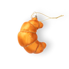 Chive glass croissant ornament in orange with a gilded thread hanger.