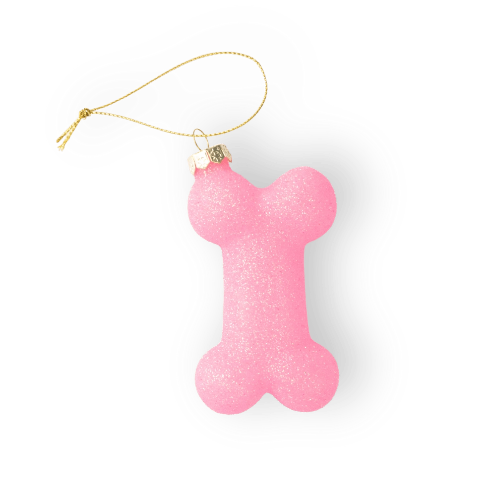 Chive glass dog bone ornament in pink with a gold cord hanger.