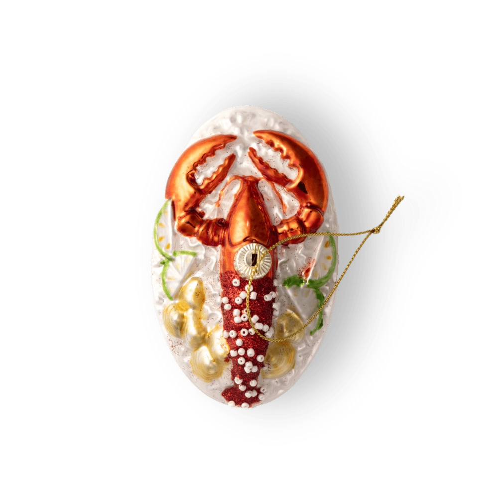 Chive glass lobster ornament, overhead view on a textured white plate.