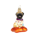 Chive glass pug ornament in a spotted sweater sitting on an orange cushion.