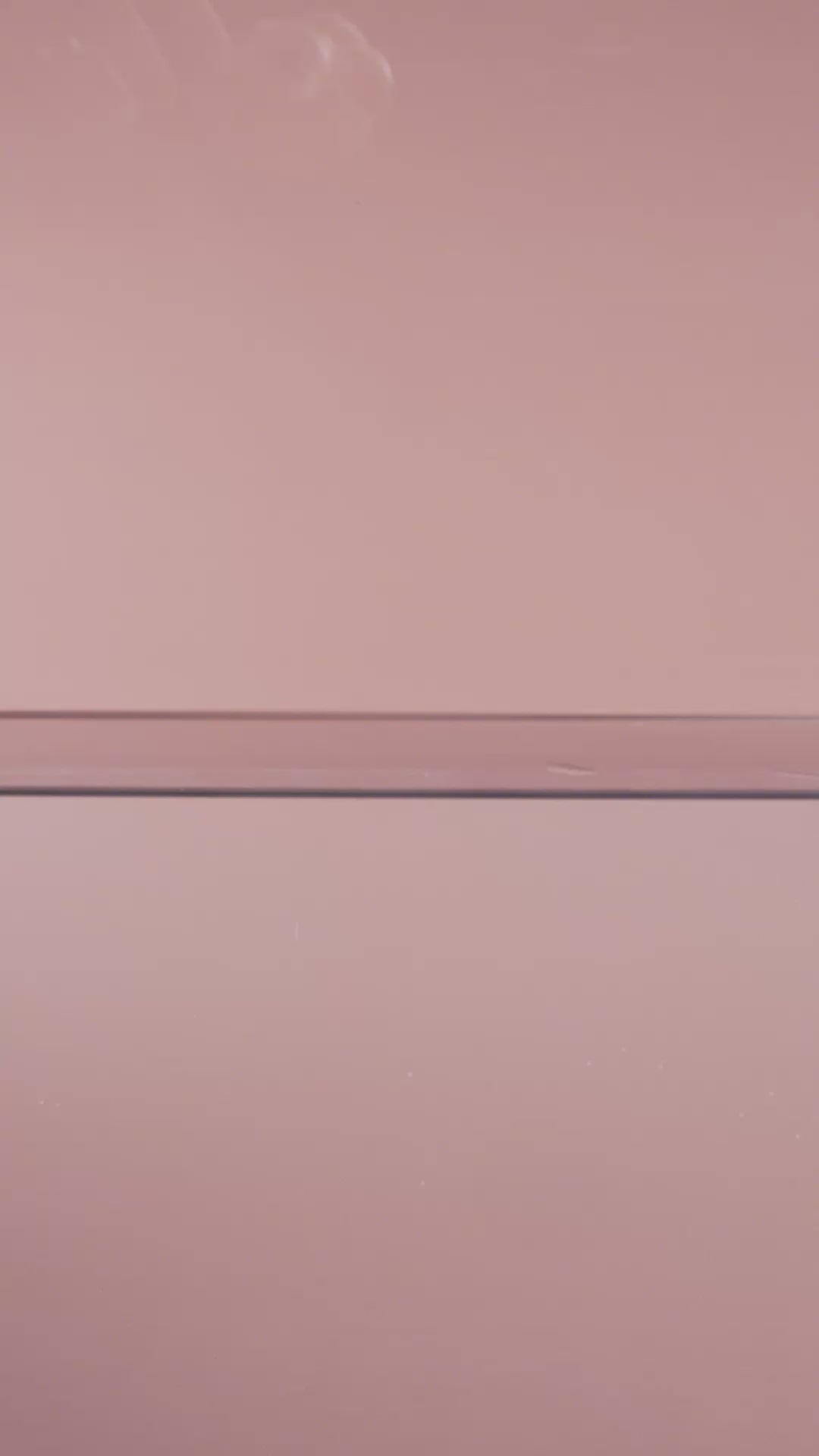 Peach pink cloni ranunculus ceramic wall flower plunging into still water creating a dramatic slow motion splash — France Collection — Chive Studio