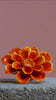 Orange yellow paris daisy ceramic wall flower shattered by sledgehammer exploding into pieces with a trail of white smoke in slow motion — France Collection — Chive Studio