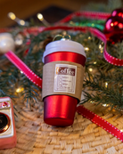 Red coffee cup ornament styled on a decorated Christmas tree